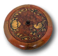 A round cookie box decorated to imitate intarsia. The outside edge of the box was painted with segments of differing woodgrain to imitate wood inlay look popular in the '60s.